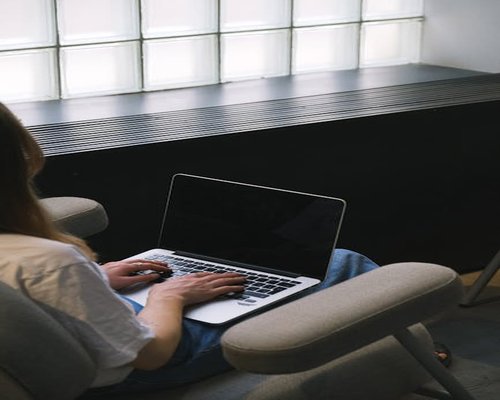 Person typing on laptop with ergonomic sitting posture
