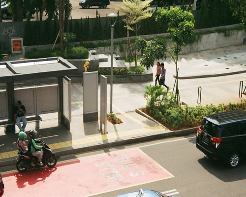 Pedestrians walking confidently on a Jakarta sidewalk