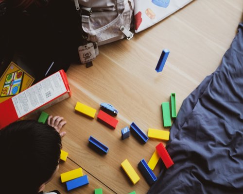 Parent and child organizing toys on the floor safely